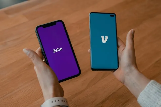 person holding two smartphones with venmo and zelle logos in each hand