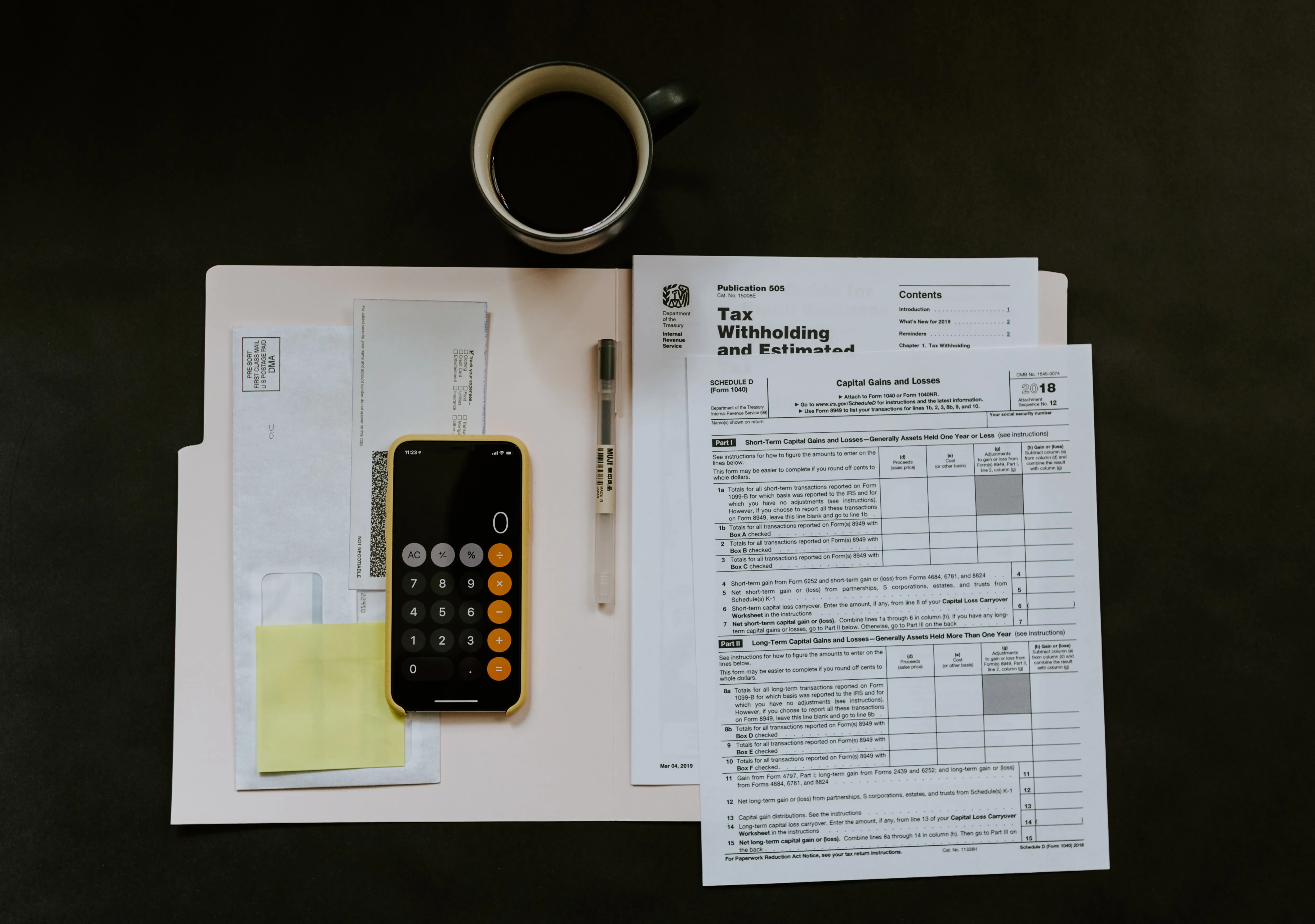 folder with tax forms, a calculator, and a cup of coffee